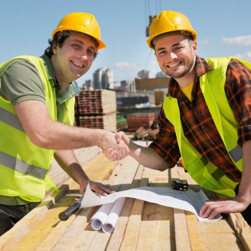 tradesmen smiling and shaking hands