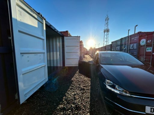 car parked beside a storage unit on a summers evening
