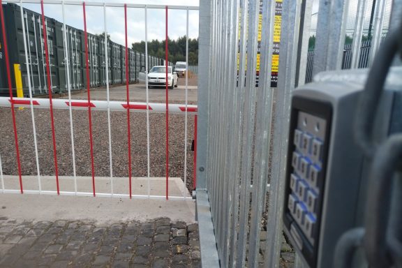 digital keypad beside a security gate leading to a storage depot