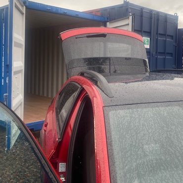 car delivering next to storage units