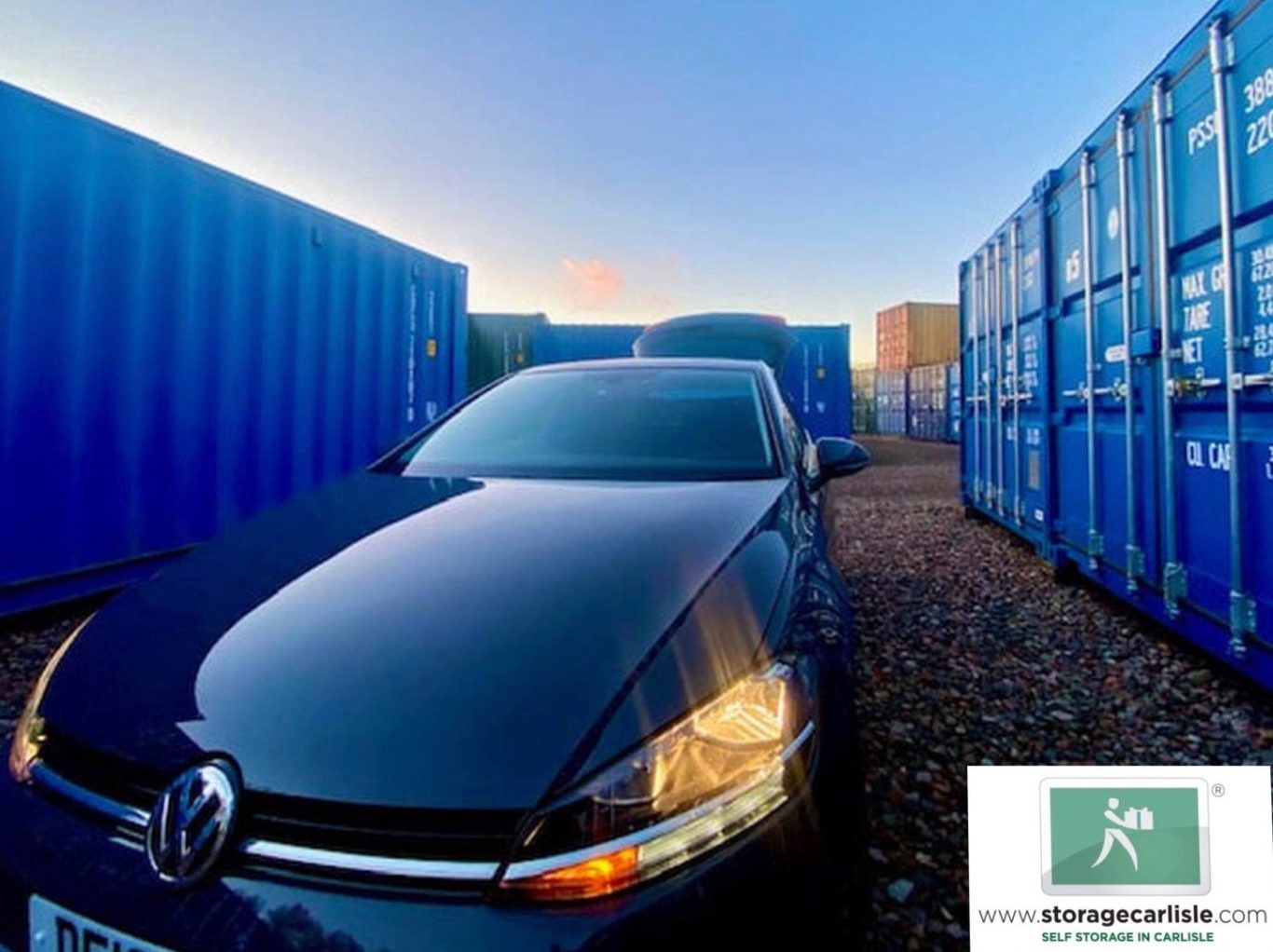 self storage depot full of shipping containers with a car in the foreground