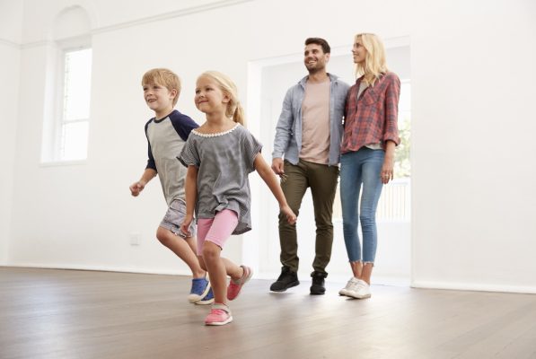 happy family opening their front door to a brand new home