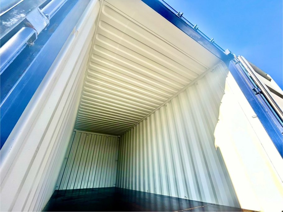 Interior of a large shipping container with bright sunlight illuminating the space.