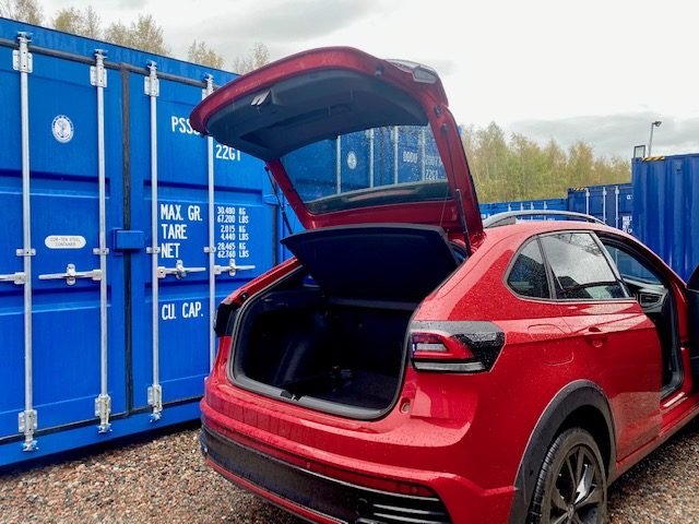 car about to unload furniture into a shipping container