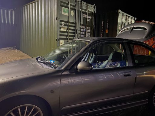 car with boot open unloading at night
