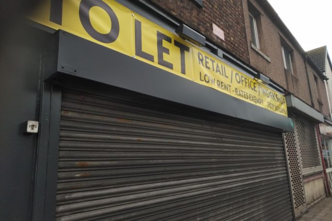 the front of a shop with a roller shutter down