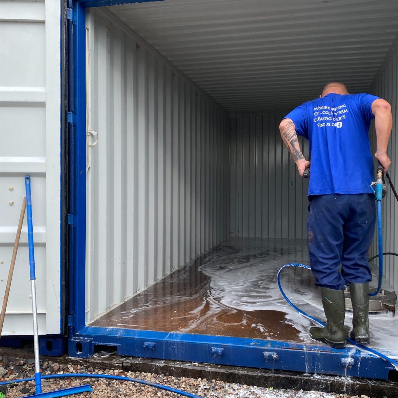 person washing a storage shipping container