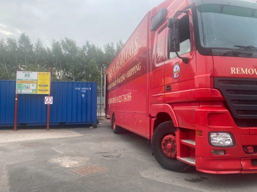 large red removals vehicle on a self storage facility