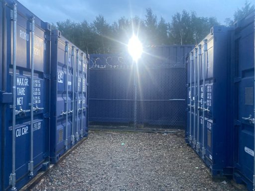 blue shipping containers at night lit up