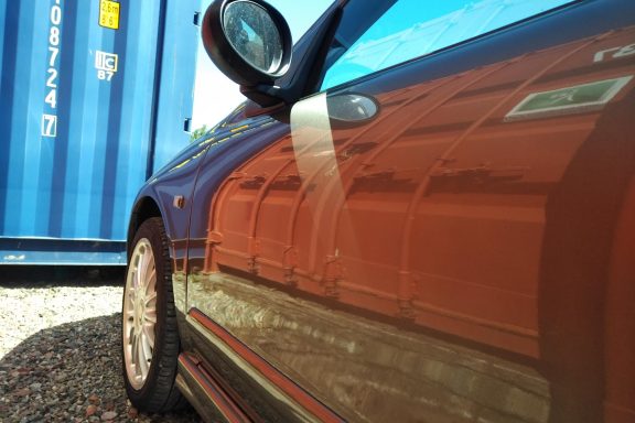 car with reflection of shipping container 