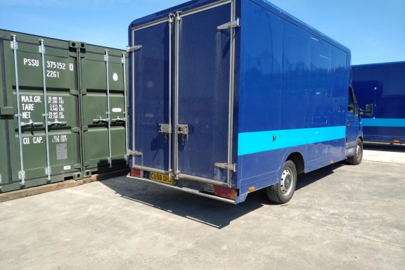 large blue van parked outside storage units