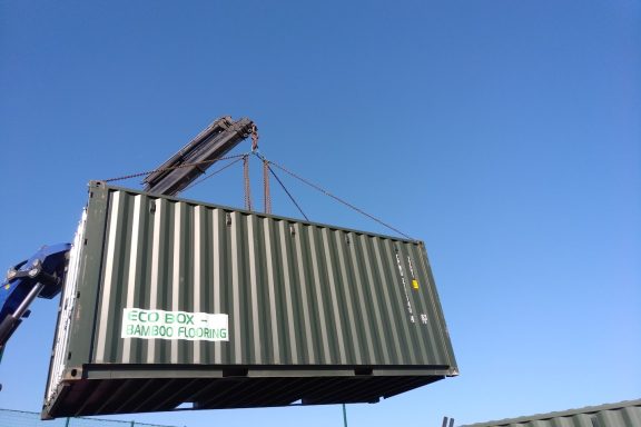 green 20 foot ISO shipping container in the air