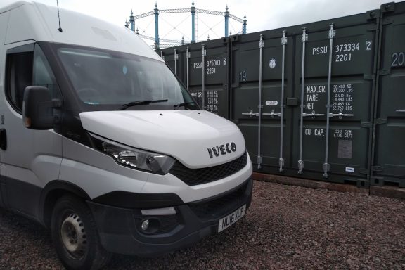 iveco van beside some shipping containers