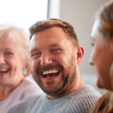 man smiling surrounded by family