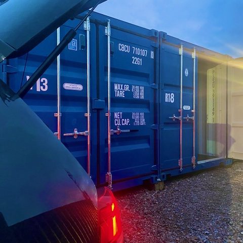 a car at night driving to a small storage container