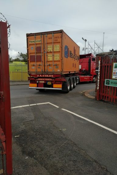 orange shipping container on the back of a lorry